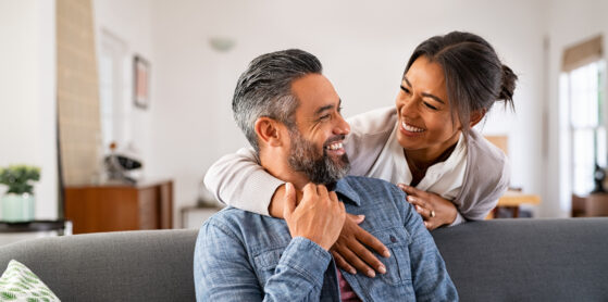 Smiling ethnic woman hugging her husband